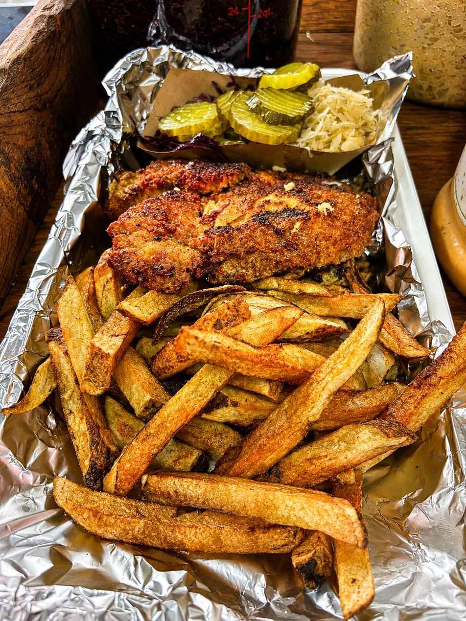 Schnitzel with hand-cut fries in a foil tray